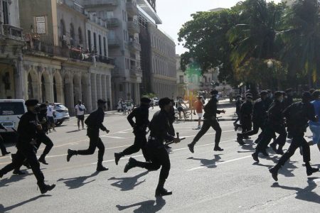 Police run during protests against and in support of the government, amidst the coronavirus disease (COVID-19) outbreak, in Havana, Cuba July 11, 2021. REUTERS/Stringer
