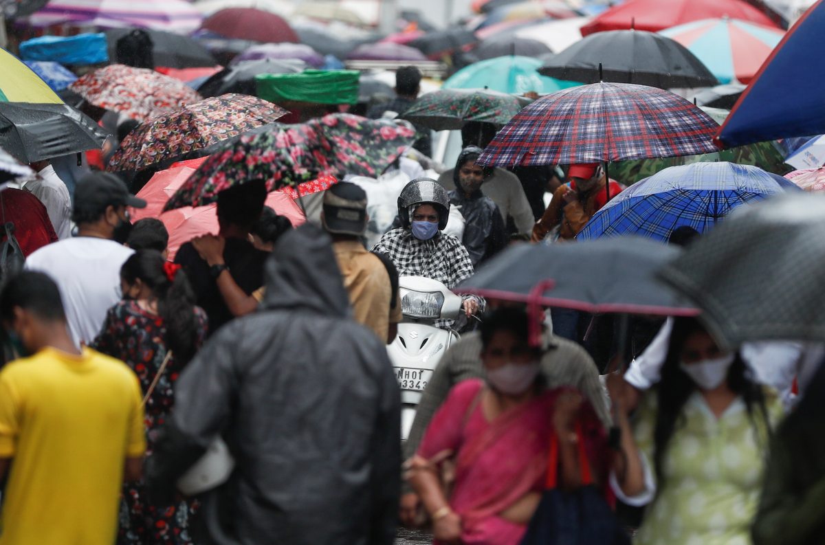 FILE PHOTO: A woman rides a scooter through a crowded market on a rainy day amidst the spread of the coronavirus disease (COVID-19) in Mumbai, India, July 14, 2021. REUTERS/Francis Mascarenhas