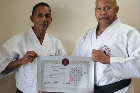Shihan Jeffrey Wong (left) receives his official certificate from Shihan Adrian Ellis.