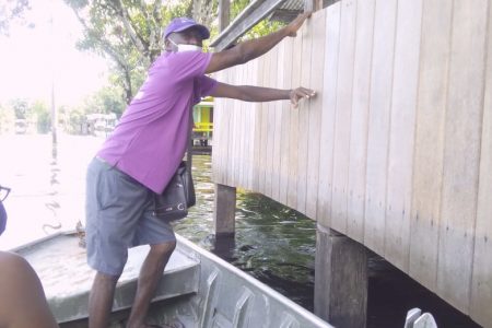 A boat moors next to a house in Kwakwani where water levels have dropped