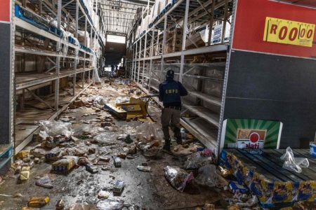 A member of the South African Police Services searches for looters inside the Gold Spot Shopping Centre in Vosloorus, Johannesburg, on July 12, 2021.PHOTO: AFP