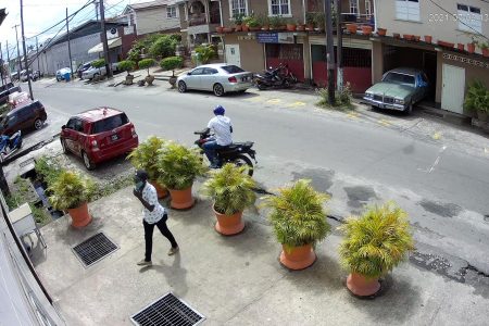 The bandit entering the funeral home while his accomplice waited on the motorcycle