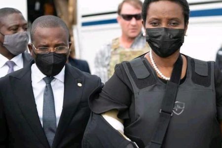 Haiti's interim Prime Minister Claude Jospeh walks with the Haiti's first lady Martine Moise, the wife of assassinated President Jovenel Moise, after she arrives from the U.S, in Port-au-Prince, Haiti, in this undated photograph obtained by Reuters on July 17, 2021. Prime Minister's Office/Handout via REUTERS