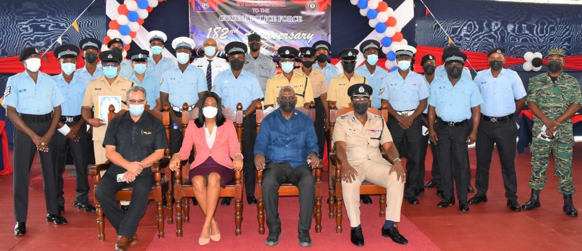 The Guyana Police Force’s 182nd Anniversary Awards Ceremony: Some of the awardees pose for a photo with (seated) the Minister of Home Affairs,  Robeson Benn (second from right), Permanent Secretary,  Mae Touissant Jr. Thomas (second from left), Commissioner of Police (Ag) Nigel Hoppie (right) and National Security Advisor, Gerry Gouveia. (Police photo)