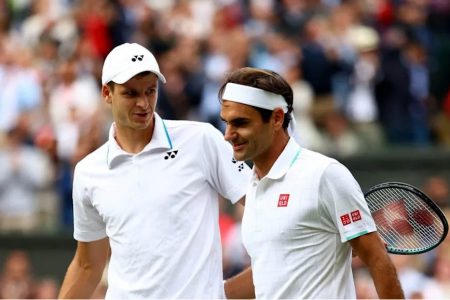 Poland’s Hubert Hurkacz, left, seems to be consoling his idol Roger Federer whom he sent packing from Wimbledon yesterday.