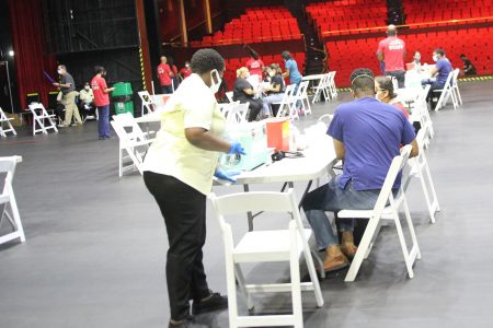 Members of the public at the American Chamber of Commerce, Chamber of Industry and Commerce and Coalition of Services Industries’ mass vaccination drive at NAPA, Port-of-Spain, yesterday. 