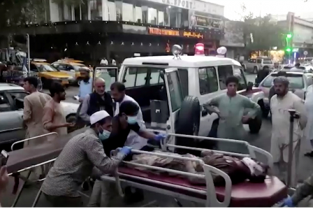A screen grab shows people carrying an injured person to a hospital after an attack at Kabul airport in Afghanistan on August 26 2021.Image: REUTERS TV/1TV/Handout via REUTERS