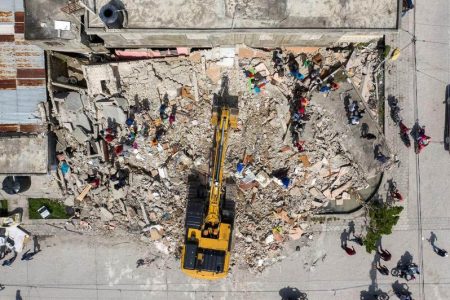 An aerial view of an excavator removing rubble from a destroyed building after Saturday’s 7.2 magnitude quake, in Les Cayes, Haiti August 18, 2021. REUTERS/Ricardo Arduengo