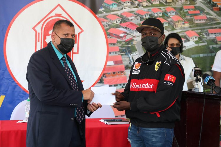 The Minister of Housing and Water handing over a cheque to one of the farmers at Cummings Lodge (Parcel 1767) (Ministry of Housing and Water photo)