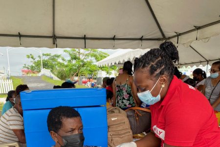 An elder taking her first dose of a COVID-19 vaccine.
