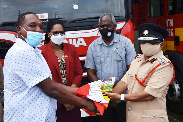 The handing over of the ceremonial colours of the GFS from Marlon Gentle (at left) to Kalamadeen Edoo in February (Ministry of Home Affairs photo)