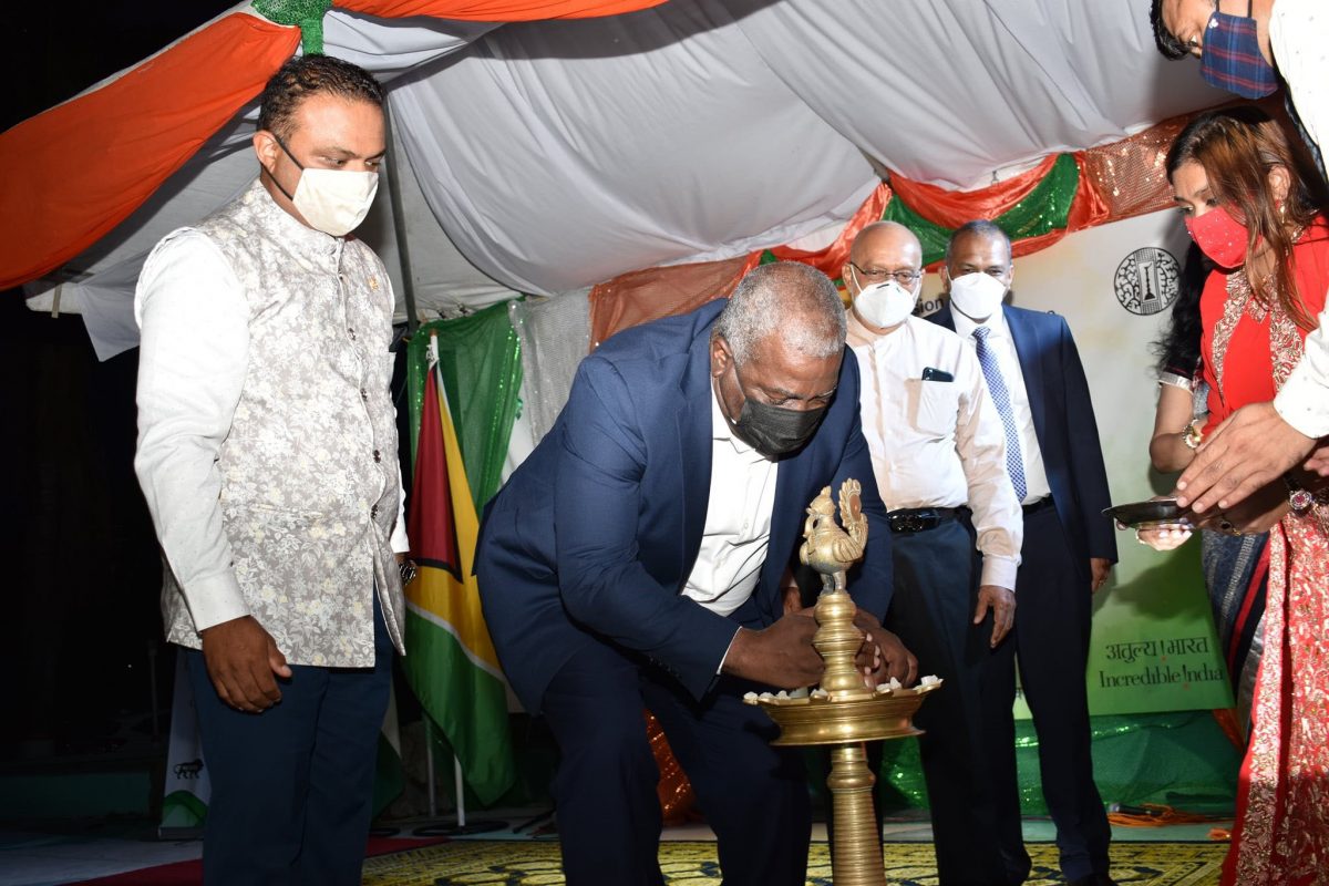 Prime Minister Mark Phillips lighting the ceremonial lamp at the cultural evening. At left is Indian High Commissioner  Dr. K.J. Srinivasa. Third from left is former President Donald Ramotar. (Indian High Commission photo)