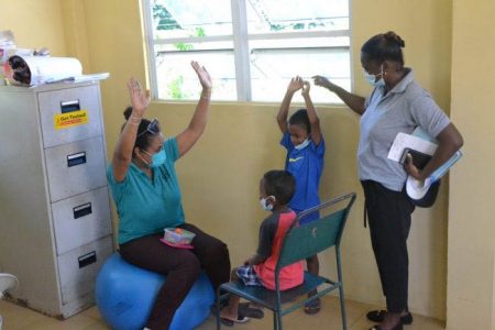 Medical staff attend to children during the Specialist Medical Outreach by the Ministry of Health on the island of Leguan, Essequibo River yesterday. (Department of Public Information photo)
