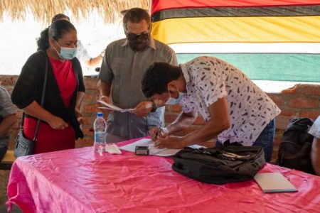 Toshao of Monkey Mountain Lincoln Abraham Singh signing the contract for the works (DPI photo) 