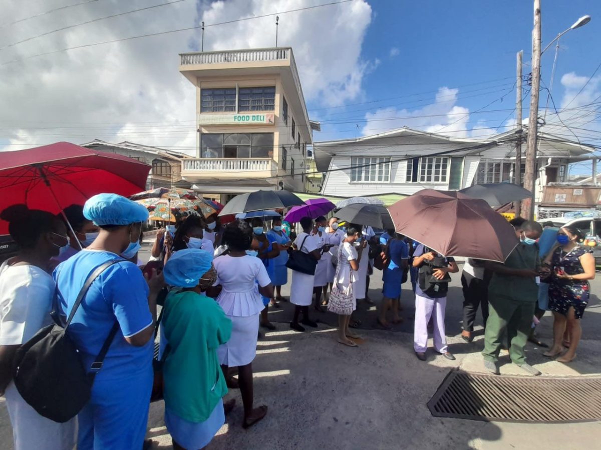 Health Care workers outside the GPHC compound yesterday. The GPHC has barred unvaccinated staff from entering the compound unless they provide a negative PCR test from a private lab. 