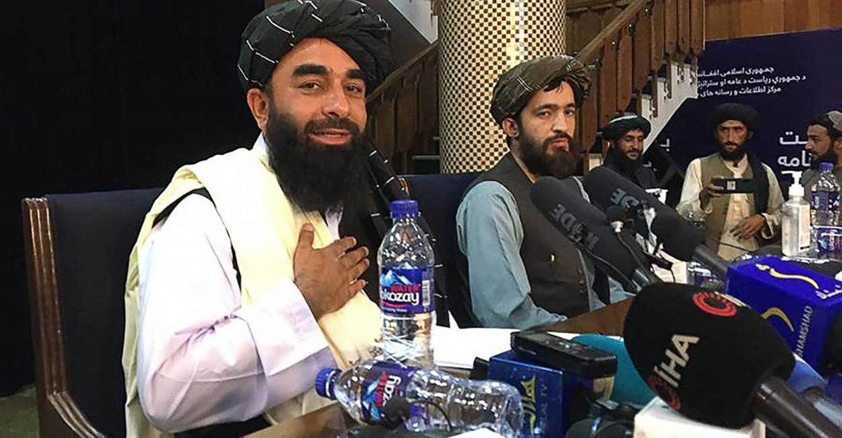Taliban spokesperson Zabihullah Mujahid (L) gestures as he arrives to hold the first press conference (AFP photo)