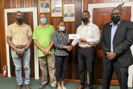  Chairman of the NSC, Kashif Muhammad makes a presentation to Aleka Persaud in the Boardroom of the National Sports Commission, in the presence of GASA president Dwayne Scott, Coach Sean Baksh and Director of Sport, Steve Ninvalle.
