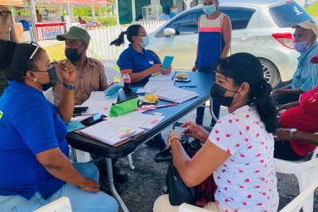 Persons gathered at the Anna Regina car park to access their vaccines recently.