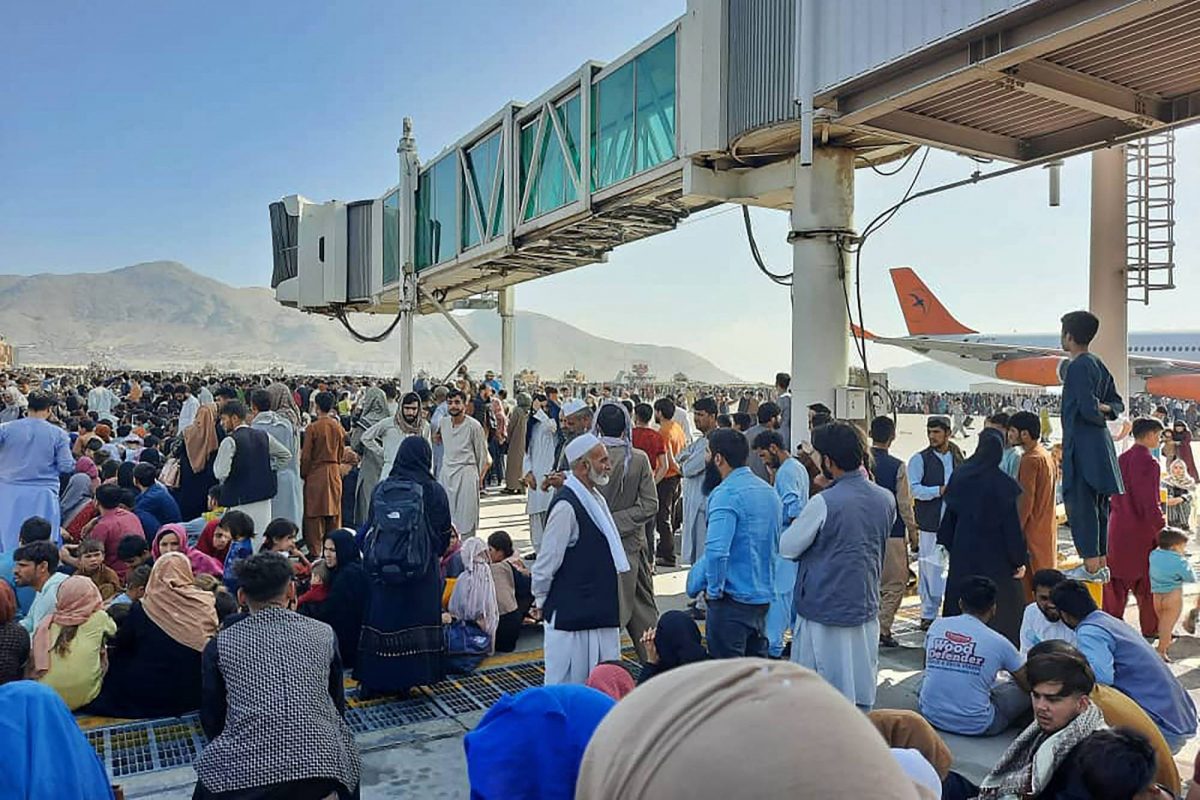 TOPSHOT – Afghans crowd at the tarmac of the Kabul airport on August 16, 2021, to flee the country as the Taliban were in control of Afghanistan after President Ashraf Ghani fled the country and conceded the insurgents had won the 20-year war. (Photo by – / AFP)