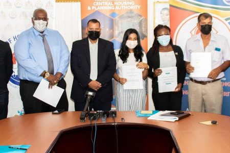 Minister of Housing and Water, Collin Croal (fourth, from left), CH&PA CEO Sherwyn Greaves (third, from left) and Permanent Secretary Andre Ally (second, from right) along with the awardees following the signing of the contracts yesterday. (Ministry of Housing and Water photo)