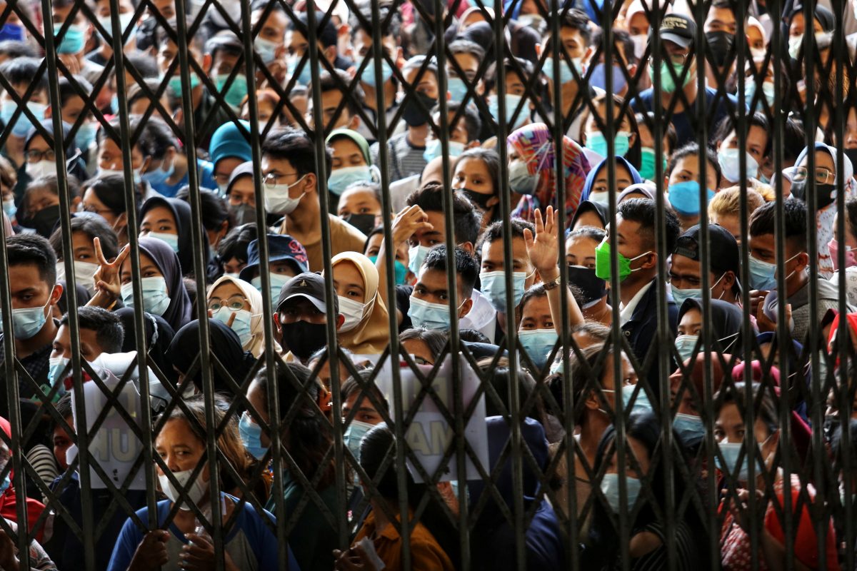 People wearing protective face masks stand in line wait to receiving a dose of the vaccine against the coronavirus disease (COVID-19), during a vaccination program at the provincial government building in Medan, North Sumatra province, Indonesia August 3, 2021, Picture taken August 3, 2021. Antara Foto/Fransisco Carolio/via Reuters