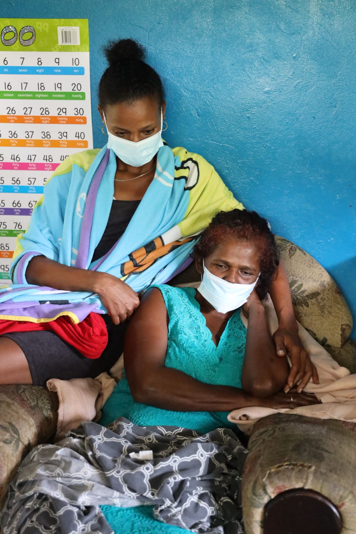 Keisha comforts her mother Alma Archargee, as she weeps for her husband Christopher Samuel, who died after their home was toppled during a landslide in Rancho Quemado, Palo Seco, yesterday.