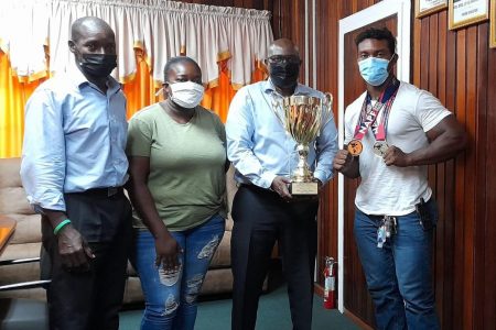 Here Ninvalle (second from right) poses with the two-time gold medalist (right) Guyana Powerlifting and Fitness Federation executive member Franklyn Brisport (left) and Pettersen-Griffith’s manager.
