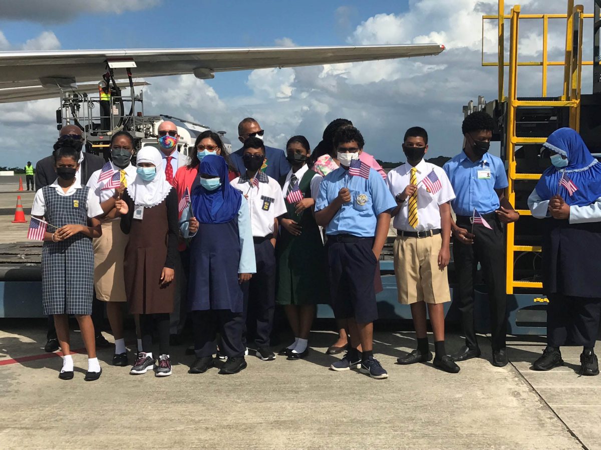 Government officials, representatives of the US Embassy and children at the airport for the arrival of the Pfizer vaccines.  (Ministry of Education photo) 