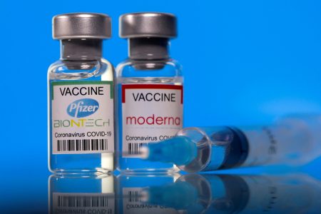 Vials with Pfizer-BioNTech and Moderna coronavirus disease (COVID-19) vaccine labels are seen in this illustration picture taken March 19, 2021. REUTERS/Dado Ruvic/Illustration/File Photo