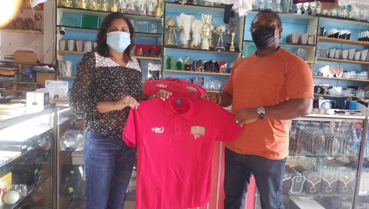 Devi Sunich of the Trophy Stall presents the Polo T-Shirts to Roger Rogers of the Guyana Amateur Powerlifting Federation.