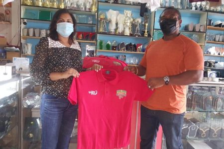 Devi Sunich of the Trophy Stall presents the Polo T-Shirts to Roger Rogers of the Guyana Amateur Powerlifting Federation.