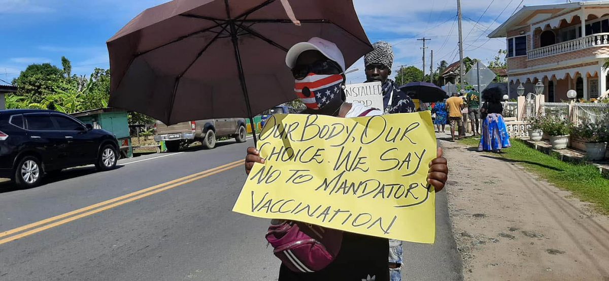 A protestor with her placard yesterday during the protest at Victoria, East Coast Demerara (APNUAFC photo)