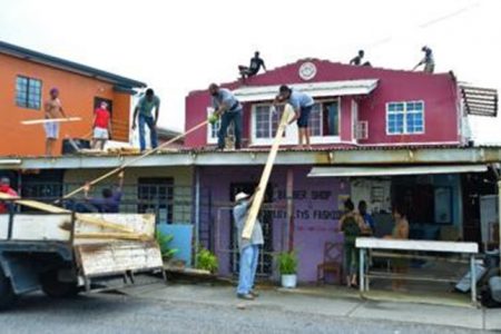 Workmen repair the roof of a house at Caroni Savannah Road, Chaguanas which was blown off by gusty winds in the early hours of yesterday morning. Photo ISHMAEL SALANDY.