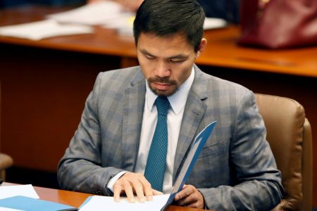  FILE PHOTO: Philippine Senator and boxing champion Manny Pacquiao reads his briefing materials as he prepares for the Senate session in Pasay city, Metro Manila, Philippines September 20, 2016. REUTERS/Erik De Castro