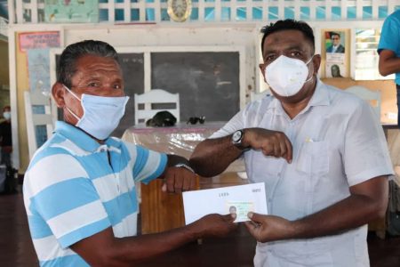 Minister of Agriculture Zulfikar Mustapha handing over a flood relief grant to a farmer in the Upper Pomeroon