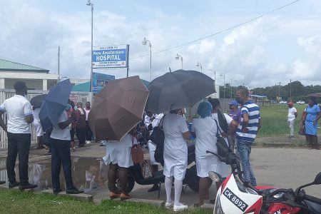 Some workers locked outside of the New Amsterdam Hospital yesterday
