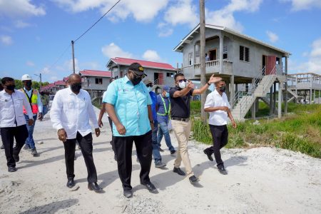President Irfaan Ali (second from left in forefront) visiting a housing project yesterday. (Office of the President photo)