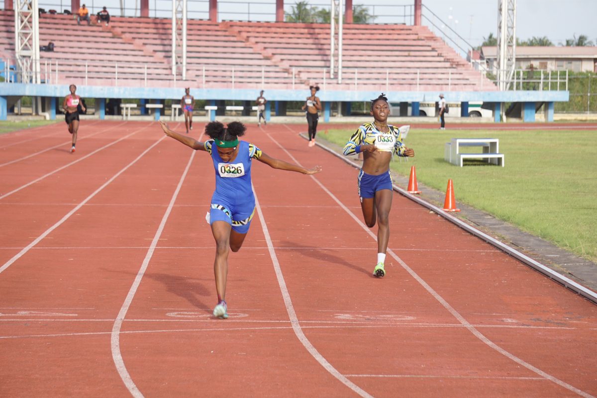 Adriel  Austin with Attoya Harvey a whisker away, powered across the finish line in 58.08s to win the girls 14-17, 400m final. (Emmerson Campbell photo)
