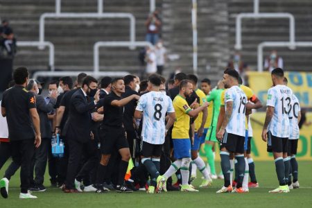 Players and officials are seen on the pitch as play is interrupted after Brazilian health officials objected to the participation of three Argentine players they say broke quarantine rules REUTERS/Amanda Perobelli.
