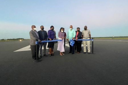 Minister of Business Oneidge Waldron accompanied by Minister of Public Works Juan Edghill and Minister of Home Affairs Robeson Benn cuts the ribbon to commission the extended CJIA runway. Also in picture is CEO of CJIA Ramesh Ghir (second left) and Chairman of Board of Directors Sanjeev Datadin (second right)