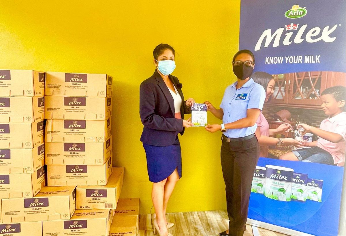 GFF Marketing Committee Chairwoman Lisa Ahmad (left) receives the symbolic donation of Milex milk powder from DeSinco representative Sarah Piggott.