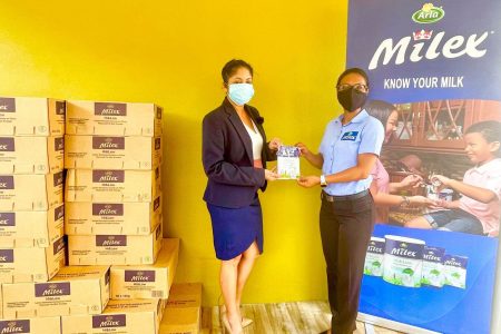GFF Marketing Committee Chairwoman Lisa Ahmad (left) receives the symbolic donation of Milex milk powder from DeSinco representative Sarah Piggott.