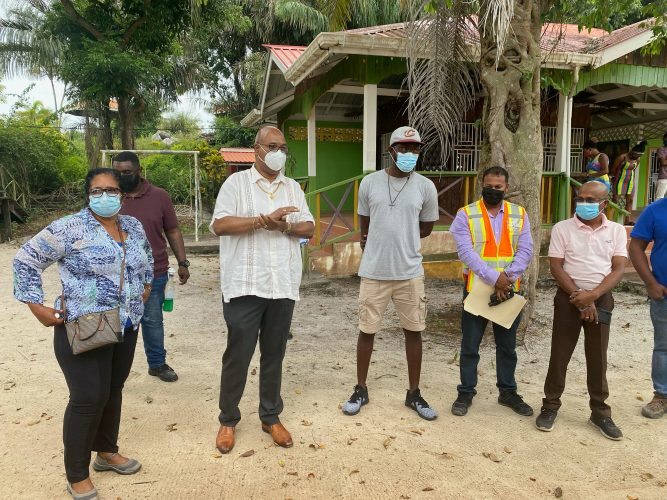 Minister of Public Works Juan Edghill (third from left) along with Regional Chairperson Vilma De Silva (left) speaking with residents.