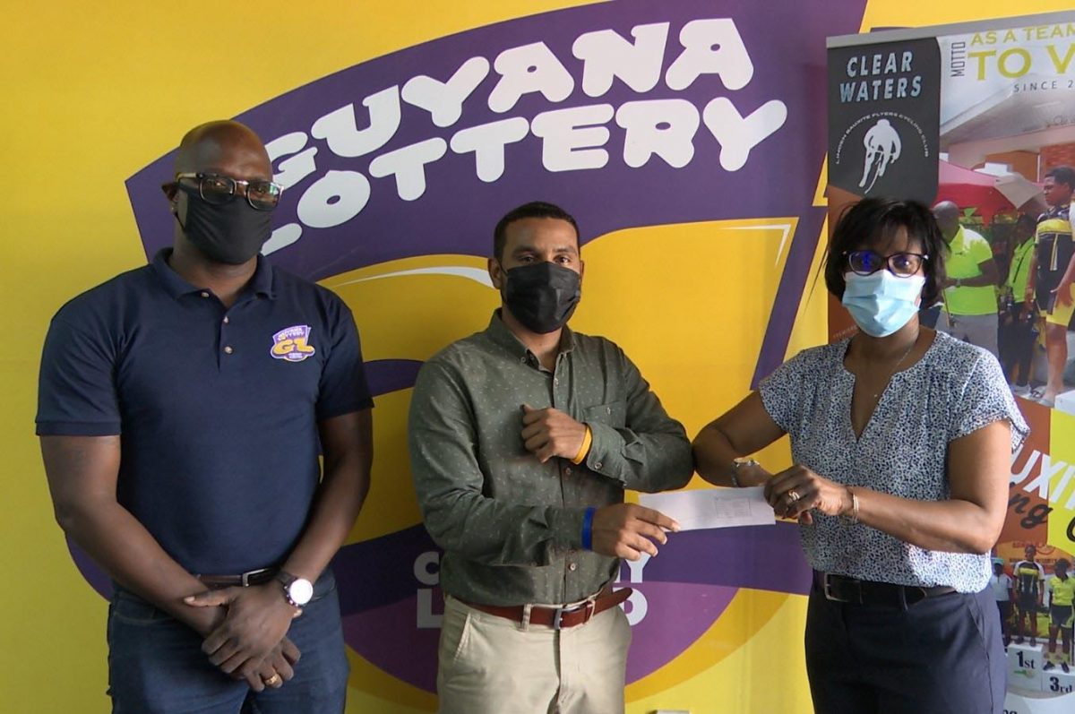 Guyana Lottery Company’s General Manager, Tracey Lewis (right), makes a presentation to Assistant Secretary/Treasurer Jeffrey Yearwood (centre) of the Linden Bauxite Flyers Cycle Club in the presence of company’s Brand Ambassador, Rawle Toney.