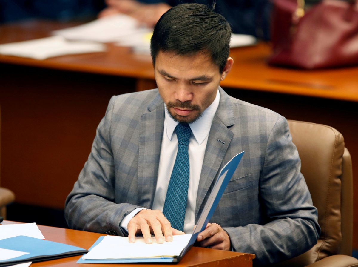 FILE PHOTO: Philippine Senator and boxing champion Manny Pacquiao reads his briefing materials as he prepares for the Senate session in Pasay city, Metro Manila, Philippines September 20, 2016. REUTERS/Erik De Castro