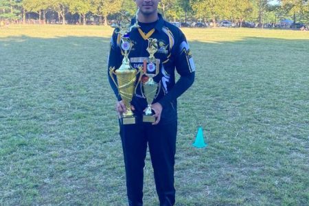 Akshaya Persaud poses with his man of the final trophy and the Deo and Sons T20 championship prize.
