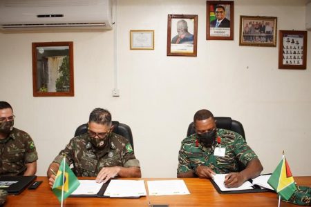 Brigadier General Adriano Fructuoso (centre) and Colonel Trevor Bowman (right) affix their signatures to the Final Minutes and New understandings at the conclusion of the meeting. (GDF photo)