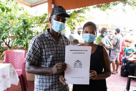 A Non Pariel couple poses with their Certificate of Title  (DPI photo)