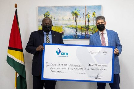GBTI CEO (ag) James Foster (right) presenting the symbolic cheque to Prime Minister Mark Phillips 