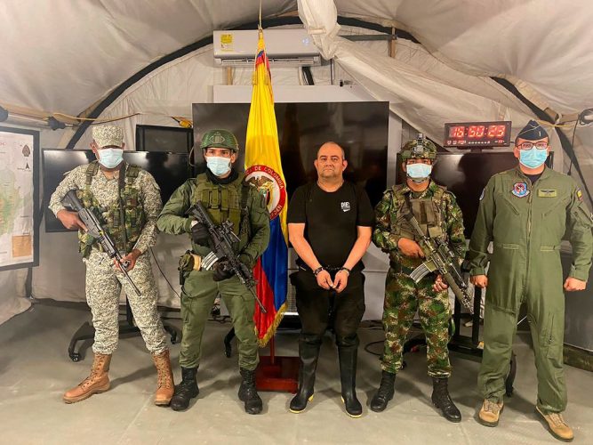Dairo Antonio Usuga David, alias "Otoniel", top leader of the Gulf clan, poses for a photo escorted by Colombian military soldiers after being captured, in Necocli, Colombia October 23, 2021. (Photo: Colombia's Military Forces/Handout via REUTERS) 